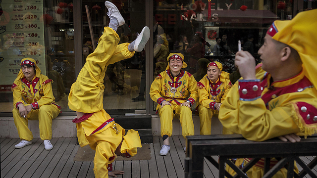 פעלולן סיני רוקד במהלך הפסקה בצילומי סרט בסאנליטון, אזור הבילויים המרכזי של בייג'ינג (צילום: גטי אימג'בנק) (צילום: גטי אימג'בנק)