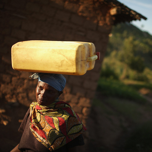ג'וליאן מוקגיהנה בת ה-63 בדרכה הביתה להכין ארוחת ערב למשפחתה בכפר נייאנזה, 70 ק"מ מבירת רואנדה קיגאלי (צילום: גטי אימג'בנק) (צילום: גטי אימג'בנק)