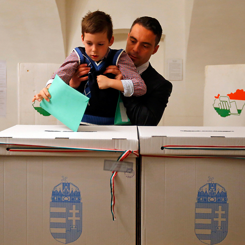 הביא את הילד להצביע. יו"ר מפלגת הימין הקיצוני "יוביק" גאבור וונה ובנו בנדק (צילום: רויטרס) (צילום: רויטרס)
