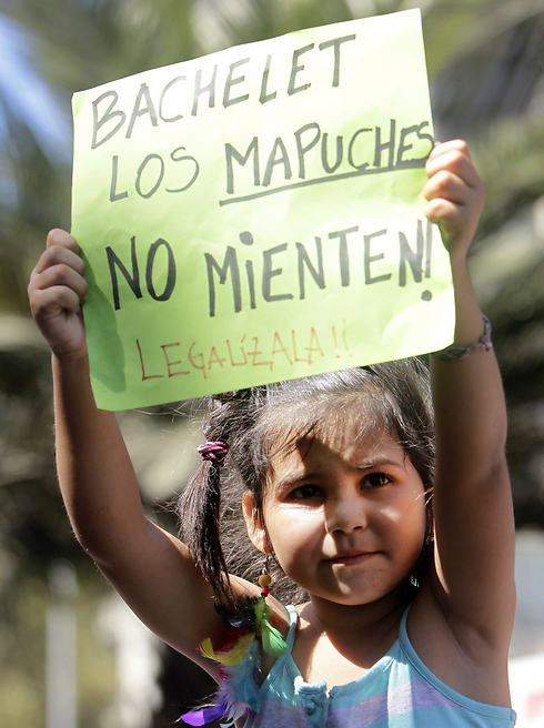 ילדה צ'יליאנית מחזיקה שלט שעליו נכתב: "בצ'לט, המפוצ'ה (הילידים של מרכז צ'ילה) לא משקרים, עגני בחוק את המריחואנה. זאת על אף שהנשיאה בצ'לט הצהירה כי לא תלך בדרכה של אורוגוואי (צילום: EPA) (צילום: EPA)