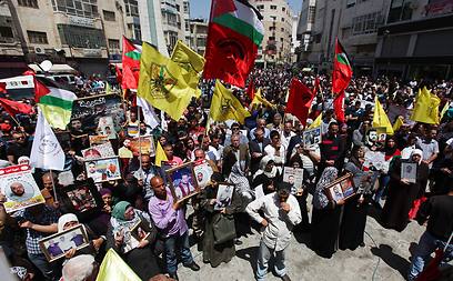 Families holding pictures of prisoners in Ramallah rally (Photo: EPA)