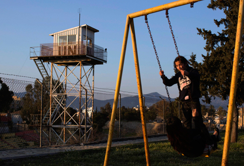 ילדה מתנדנדת במגרש משחקים בצפון קפריסין בסמוך למגדל שמירה של האו"ם (צילום: רויטרס) (צילום: רויטרס)