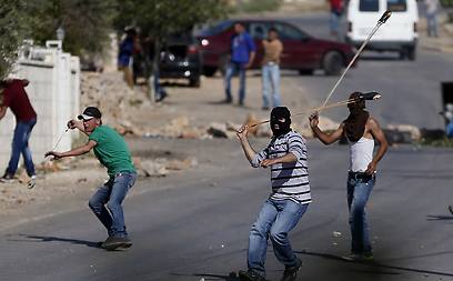 Palestinians hurl stones at Israeli security forces in Silwad (Photo: AFP)