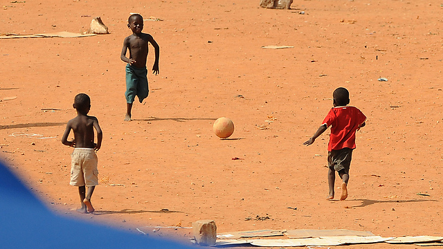 ילדים משחקים כדורגל בחולות אנגולה (צילום: AFP) (צילום: AFP)