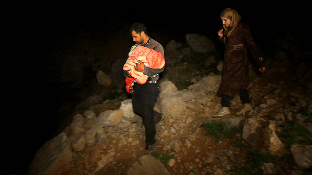 זוג פליטים סורים עם בנם התינוק מגיעים ללבנון (צילום: AP) (צילום: AP)