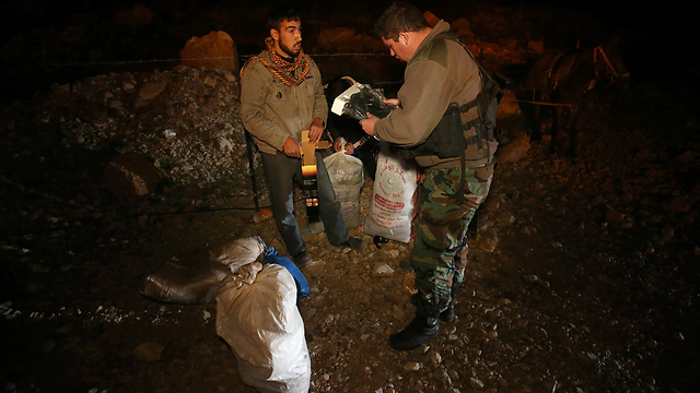 חייל לבנוני עורך חיפושים בחפציו של פליט סורי (צילום: AP) (צילום: AP)