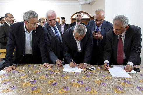 Yet to see real unity. Members of Hamas and Fatah signing the reconciliation agreement (Photo: Reuters)