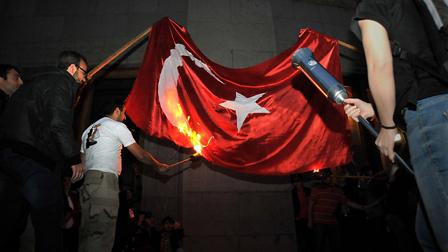 מפגינים ארמנים מציתים את דגל טורקיה (ארכיון) (צילום: AFP) (צילום: AFP)