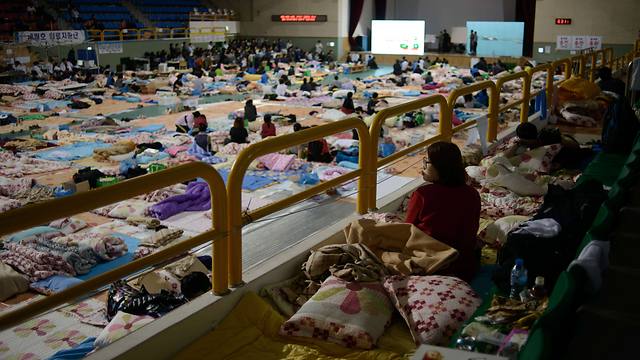 קרובי התלמידים הנעדרים ישנים באולם ספורט בתיכון שלהם (צילום: AFP) (צילום: AFP)