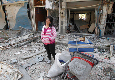 Woman stands in the ruins of her home (Photo: Reuters)