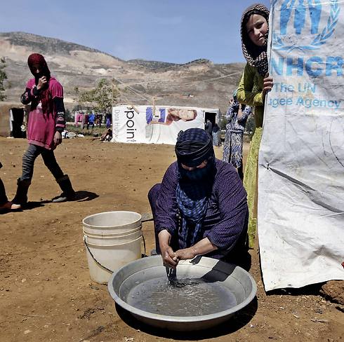 Halbiya, 50, who fled her home from Deir al-Zour, washes her hands after working on a field, at a Syrian refugee camp in Lebanon (Photo: AP) (Photo: AP)