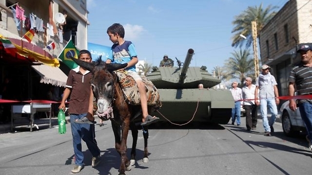 The tank replica dragged through the streets by a donkey