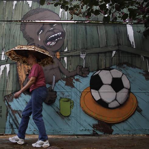 ציור קיר מחאתי. כדורגל יש, אוכל לילדים - לא (צילום: רויטרס) (צילום: רויטרס)