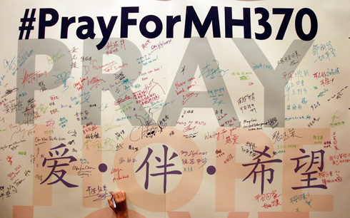 "התפללו לטיסה MH370". לוח שנתלה בקואלה לומפור (צילום: AP) (צילום: AP)