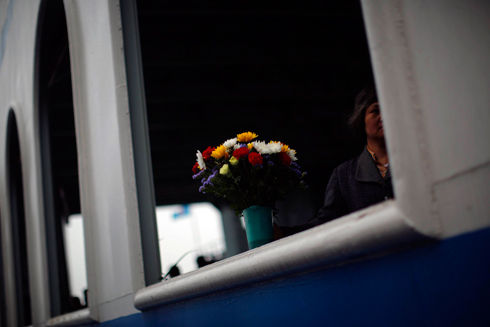 פרחים על המעבורת, ואישה העומדת לפזר אפר של קרוב (צילום: רויטרס) (צילום: רויטרס)