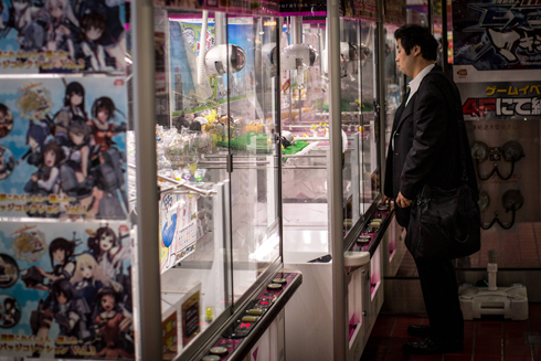 תושב טוקיו ליד חנות צעצועים מקומית שבה מוכרים חוברות קומיקס (מנגה) (צילום: Gettyimages) (צילום: Gettyimages)