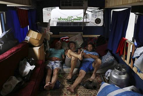 נחים בדרך לברזיל. אוהדי צ'ילה ישנים באוטובוס (צילום: AP) (צילום: AP)