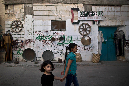 אחיות פלסטיניות ליד חנות מזכרות במחנה הפליטים עאידה בבית לחם (צילום: AP) (צילום: AP)