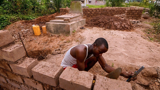 גבר בונה את ביתו בבית הקברות (צילום: AFP) (צילום: AFP)