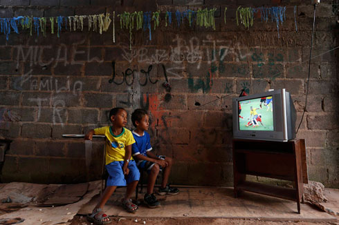 ילדים צופים במשחק בין ברזיל למכסיקו בשכונת עוני בברזיליה (צילום: רויטרס) (צילום: רויטרס)