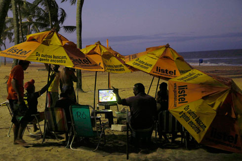 צופים במשחק הפתיחה בין ברזיל לקרואטיה עם שמשיות על החוף ברסיפה, ברזיל (צילום: רויטרס) (צילום: רויטרס)