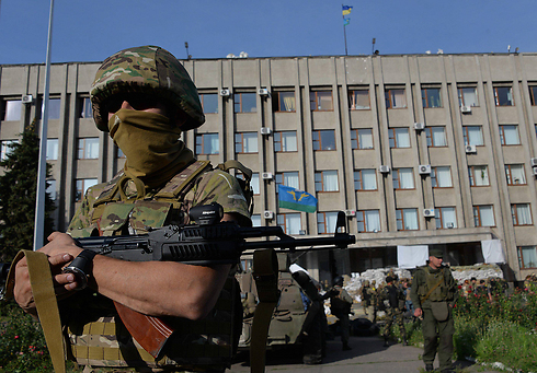 חייל אוקראיני ליד בניין העירייה בסלביאנסק ששוחרר מידי הבדלנים בשבוע שעבר (צילום: EPA) (צילום: EPA)