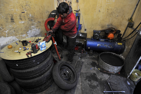 "אל צ'ינו" עובד בתיקון צמיגים בלה פז (צילום: AFP) (צילום: AFP)