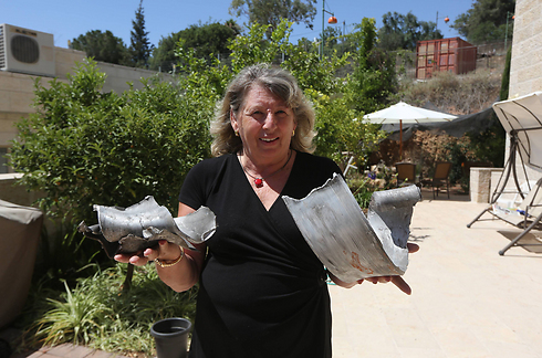 Israeli woman holding rocket fragments (Photo: Gil Yohanan)