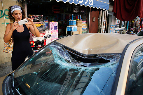 רכב נפגע משרידי הרקטה בפלורנטין (צילום: רויטרס) (צילום: רויטרס)