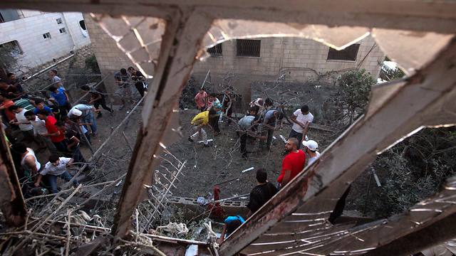 Residents examining the destruction caused by a Gaza rocket that hit a Hebron home (Photo: EPA)
