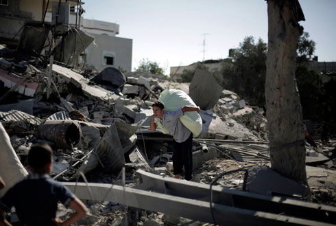 Palestinians rummaging through wreckage of house bombed by IAF (Photo: AP)