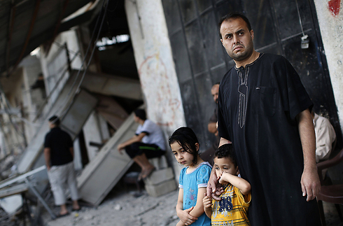 פלסטינים מחוץ לביתו של א-זהאר שהופצץ  (צילום: AFP) (צילום: AFP)