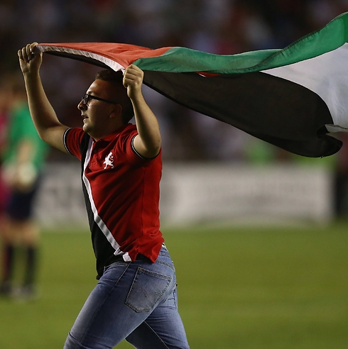 אוהד פורץ למגרש עם דגל פלסטין (צילום: AFP) (צילום: AFP)