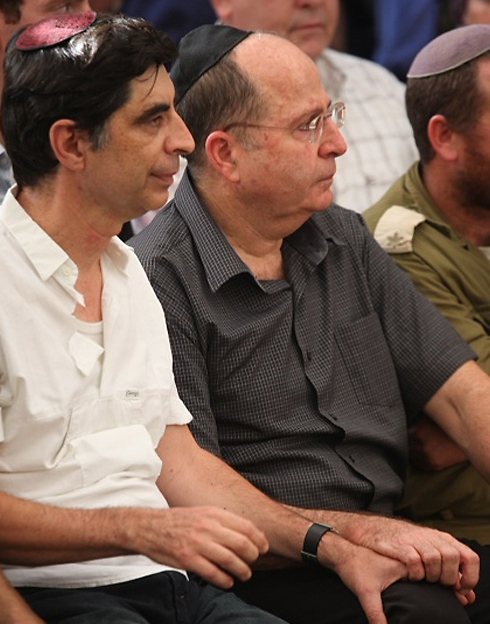 Defense Minister Moshe Ya'alon holding the hand of Hadar's father Simcha at the funeral (Photo: Motti Kimchi)