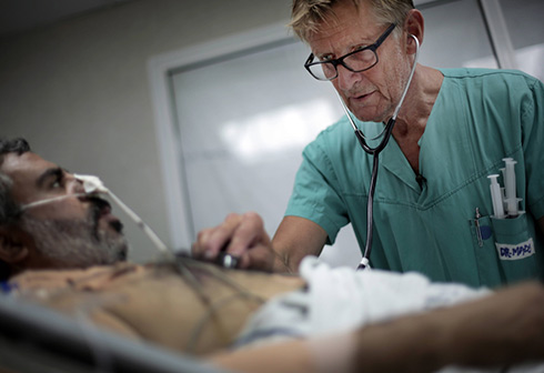 "כשאין חשמל מוציאים פלאפונים, מאירים את החדר ומנתחים". ד"ר מאדס גילברט מנורבגיה מתנדב בשיפא לסירוגין זה 17 שנה (צילום: AP) (צילום: AP)