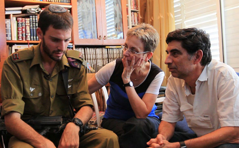First Lieutenant Eitan, who ran into the tunnel to search for Hadar Goldin, with Goldin's parents (Photo courtesy of Itamar Cohen, Yoki Photography)