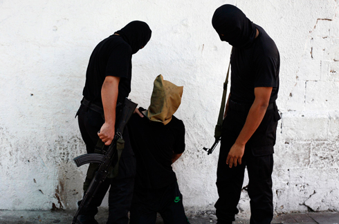 אנשי חמאס לובשי שחורים מוציאים "משת"פים" להורג. בניגוד לדאעש, החוק האיסלאמי מוחל בהדרגה (צילום: רויטרס) (צילום: רויטרס)