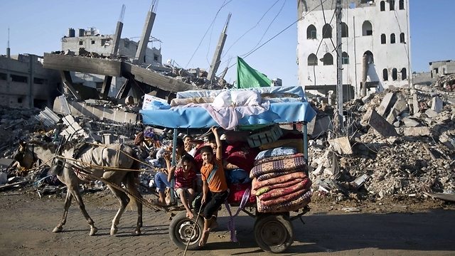 פלסטינים חוזרים לבתיהם בשכונת סג'עייה לאחר מבצע צוק איתן (צילום: AFP) (צילום: AFP)