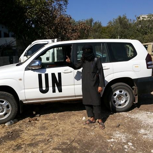 A jihadist in Syria next to a captured UN vehicle.