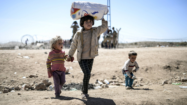 Kurdish children passing the border into Turkey. (Photo: AFP) (Photo: AFP)