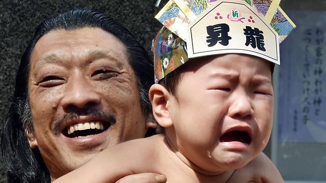 סימן לבריאות! תינוק בוכה בידי מתאבק (צילום: AFP) (צילום: AFP)