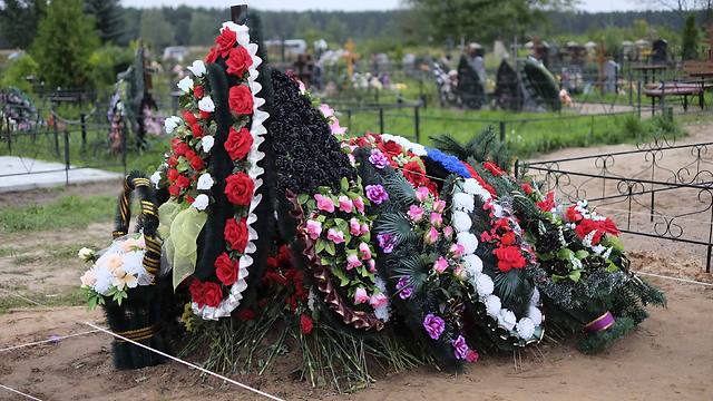 קבר טרי שנטען כי הוא של אחד הצנחנים הרוסים שנהרגו באוקראינה (צילום: AFP) (צילום: AFP)