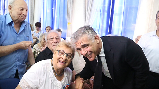 New budget to include increased stipends to elderly. Lapid at a Rosh Hashanah event for Holocaust survivors (Photo: Motti Kimchi)