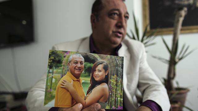 סאהין מחזיק תמונה שלו ושל גרושתו אסיה (צילום: AP) (צילום: AP)