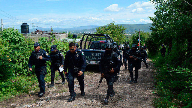 שוטרים באזור מציאת קברי האחים בעיר איגואלה (צילום: EPA) (צילום: EPA)
