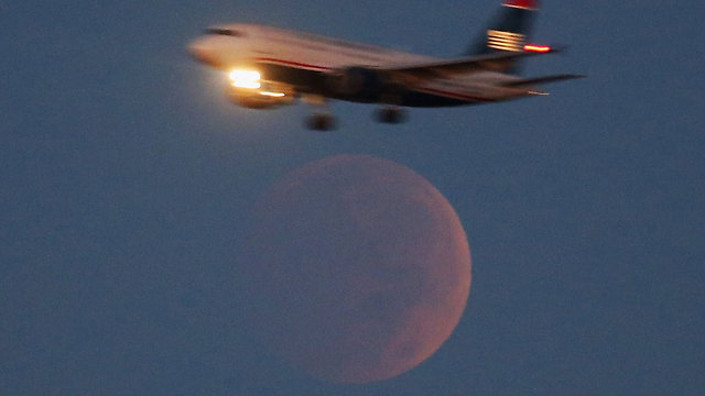 מטוס ממריא דרך ירח כמעט שקוף בוושינגטון (צילום: AFP) (צילום: AFP)