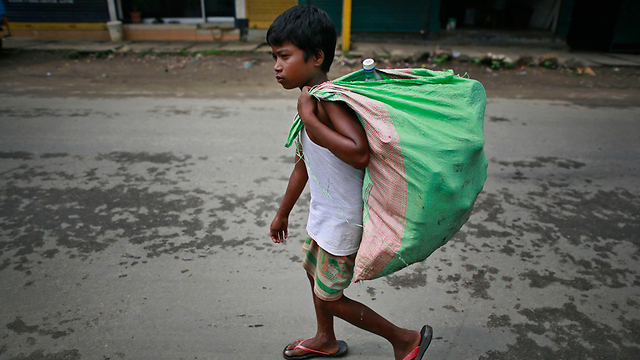אריפול רק בן 8 ועובד באיסוף שקים ובגדים (צילום: AP) (צילום: AP)