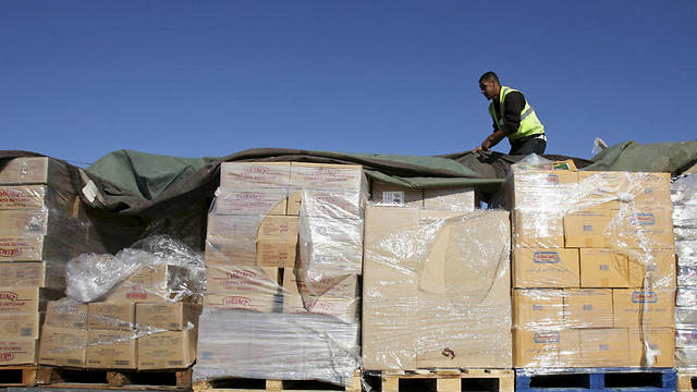 Palestinian worker checks a truck loaded with aid (Photo: AP) (Photo: AP)