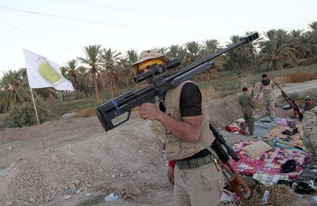 A Shi'ite fighter carries his weapon during a patrol in Jurf al-Sakhar (Photo: Reuters) (Photo: Reuters)