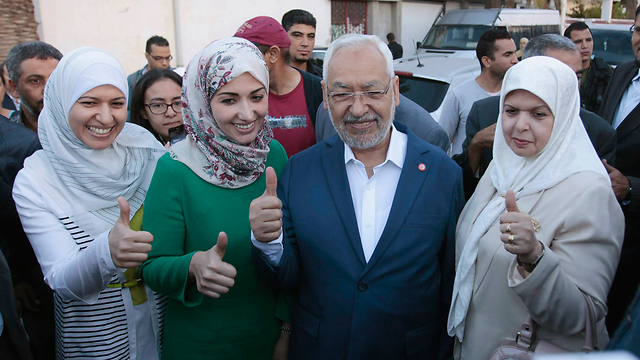 אין לו סיבות לחייך. ראשיד רנושי, ראש מפלגת "א-נהדה" עם רעייתו ושתי בנותיו סומאייה ויוסרה (צילום: רויטרס) (צילום: רויטרס)